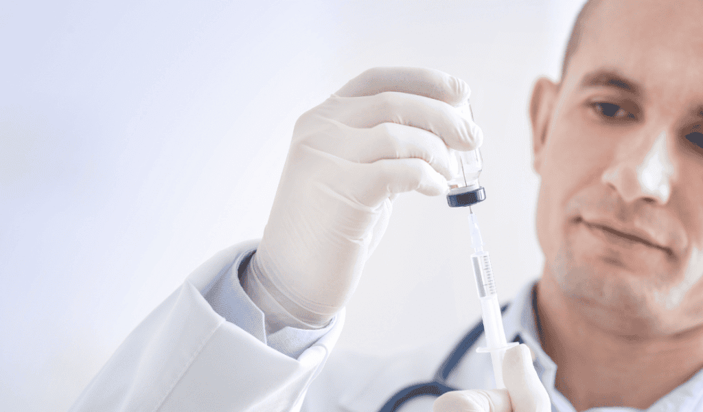 Medical professional preparing a syringe with a vaccine or medication.