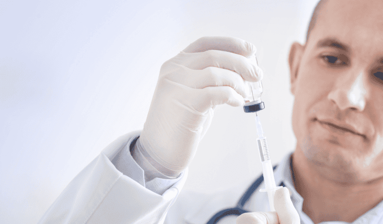 Medical professional preparing a syringe with a vaccine or medication.