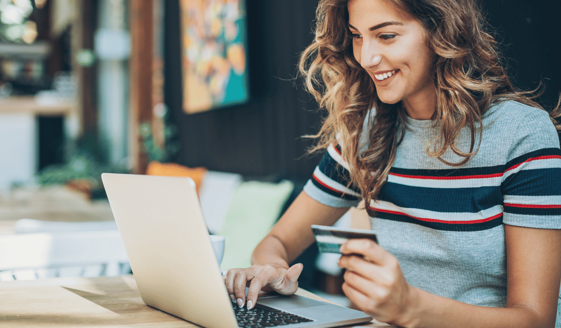 Woman using laptop and credit card for patient responsibility payment.