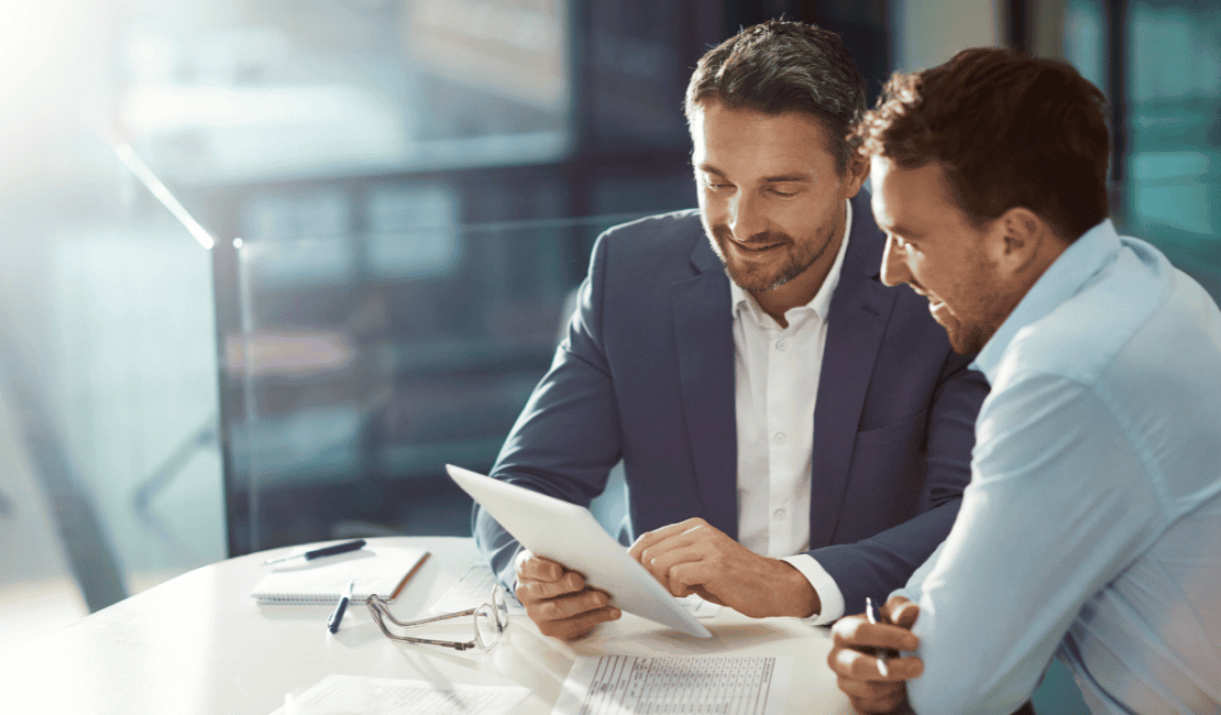 Two professionals discussing payer strategy and contracting in a modern office.